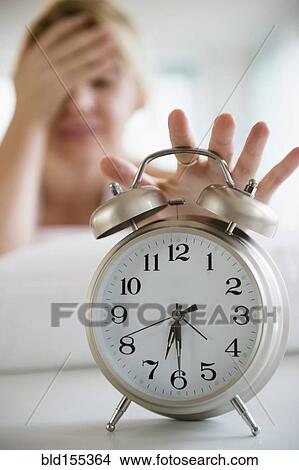 Caucasian woman shutting off alarm clock View Large Photo Image Picture - Caucasian woman shutting off alarm clock. Fotosearch