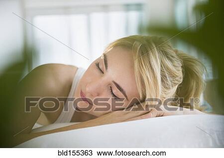 Stock Image - Caucasian woman sleeping in bed. Fotosearch