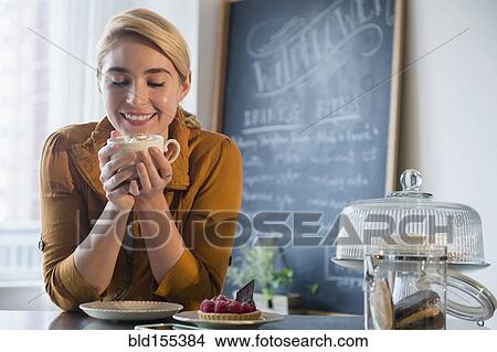 Caucasian woman smelling cup of coffee in cafe View Large Photo Image Picture - Caucasian woman smelling cup of coffee in cafe. Fotosearch