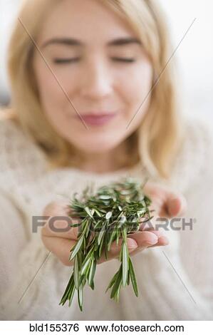 Stock Photograph - Caucasian woman smelling fresh herbs. Fotosearch