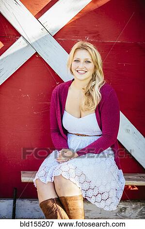 Stock Photo - Caucasian woman smiling outside barn. Fotosearch