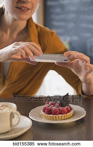 Caucasian woman taking cell phone photograph of dessert in cafe View Large Photo Image Stock Photography - Caucasian woman taking cell phone photograph of dessert in cafe. Fotosearch