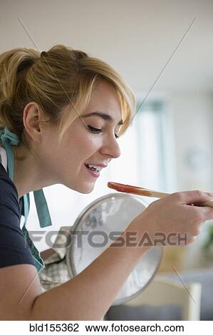 Caucasian woman tasting sauce while cooking in kitchen View Large Photo Image Stock Image - Caucasian woman tasting sauce while cooking in kitchen. Fotosearch