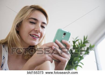 Stock Image - Caucasian woman using cell phone. Fotosearch