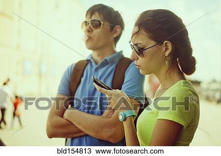 Caucasian woman using cell phone with boyfriend outdoors View Large Photo Image Stock Image - Caucasian woman using cell phone with boyfriend outdoors. Fotosearch