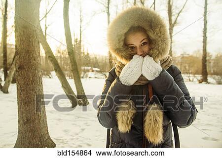 Picture - Caucasian woman wearing fur hood and coat in snowy field. Fotosearch