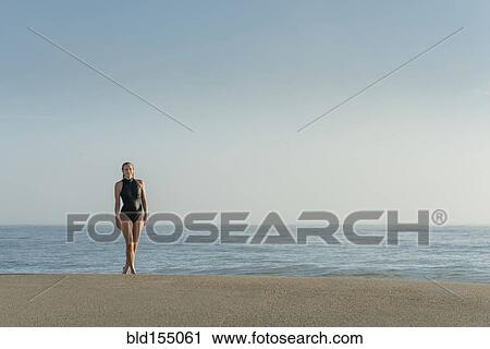 Stock Image - Caucasian woman wearing swimsuit on beach. Fotosearch