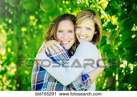 Caucasian women hugging under tree View Large Photo Image Stock Image - Caucasian women hugging under tree. Fotosearch