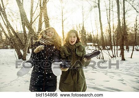 Stock Photograph - Caucasian women playing in snowy field. Fotosearch