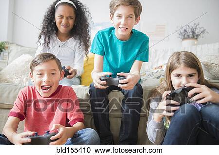 Children playing video games on sofa View Large Photo Image Stock Image - Children playing video games on sofa. Fotosearch