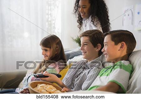 Stock Photo - Children watching television on sofa. Fotosearch