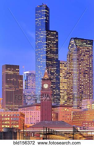 Stock Image - "Clock tower and illuminated high rise buildings in Seattle city skyline, Washington, United States". Fotosearch