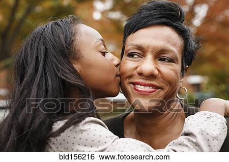 Close up of African American girl kissing mother View Large Photo Image Stock Photograph - Close up of African American girl kissing mother. Fotosearch