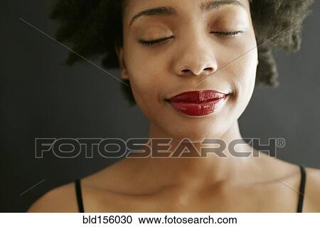 Stock Image - Close up of black woman with eyes closed. Fotosearch
