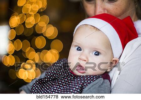 Stock Photo - Close up of Caucasian baby girl wearing Santa hat. Fotosearch