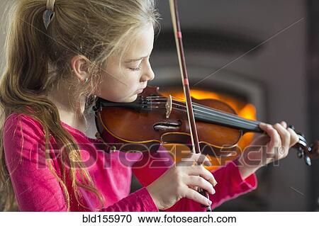 Stock Image - Close up of Caucasian girl practicing violin. Fotosearch