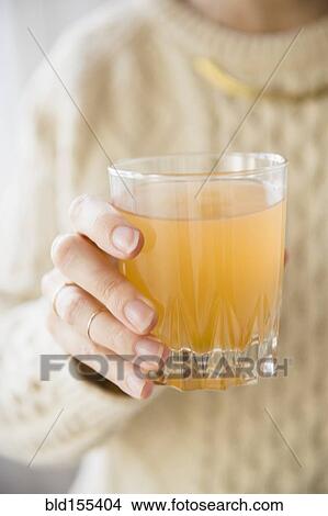 Picture - Close up of Caucasian woman holding glass of punch. Fotosearch