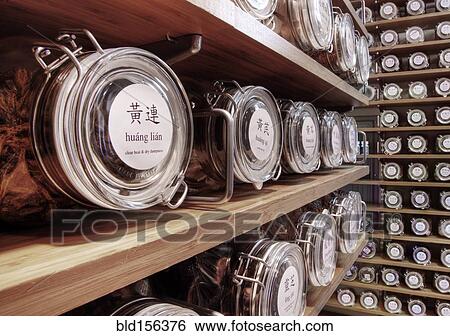 Stock Photograph - Close up of dried teas in jars on shelves. Fotosearch