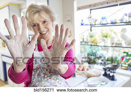 Stock Image - Close up of flour on hands of older Caucasian woman. Fotosearch