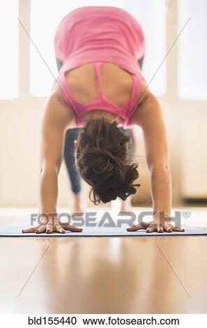 Stock Image - Close up of Hispanic woman practicing yoga in studio. Fotosearch