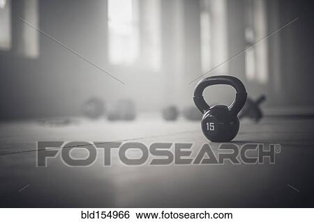 Close up of kettlebell weights on floor of dark gym View Large Photo Image Stock Photograph - Close up of kettlebell weights on floor of dark gym. Fotosearch