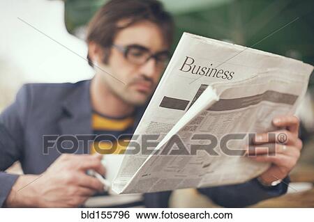 Stock Photograph - Close up of man reading business section of newspaper. Fotosearch