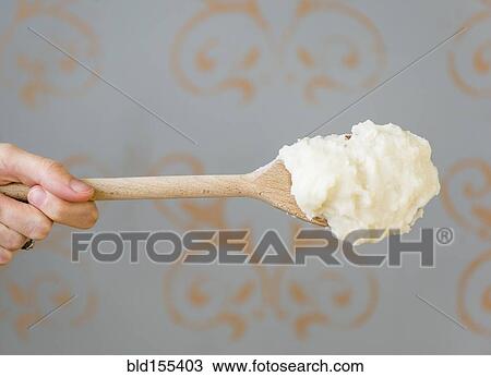 Stock Image - Close up of mashed potatoes on wooden spoon. Fotosearch