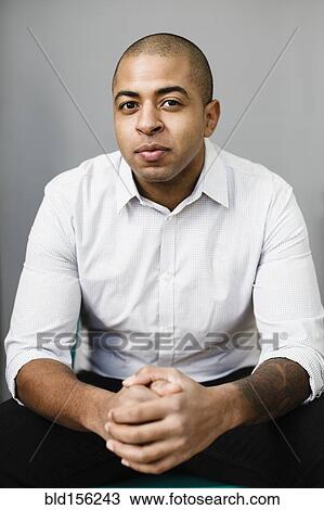 Stock Image - Close up of mixed race businessman with hands clasped. Fotosearch