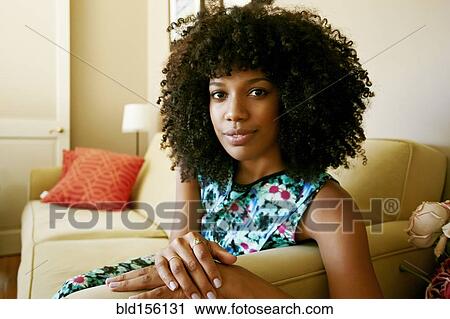 Close up of mixed race woman sitting on sofa View Large Photo Image Stock Image - Close up of mixed race woman sitting on sofa. Fotosearch