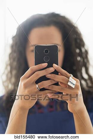 Stock Image - Close up of mixed race woman using cell phone. Fotosearch