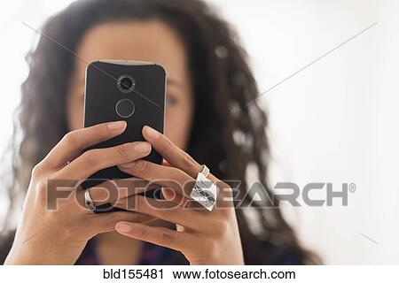 Stock Image - Close up of mixed race woman using cell phone. Fotosearch