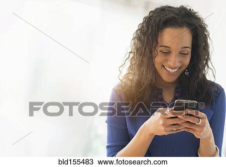 Stock Image - Close up of mixed race woman using cell phone. Fotosearch