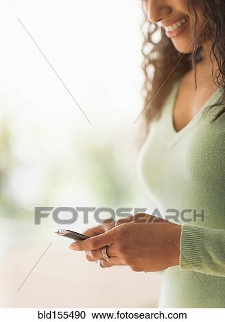 Stock Image - Close up of mixed race woman using cell phone. Fotosearch