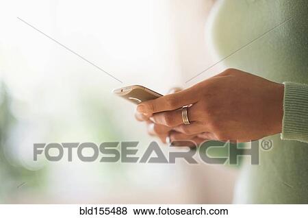 Stock Photo - Close up of mixed race woman using cell phone. Fotosearch