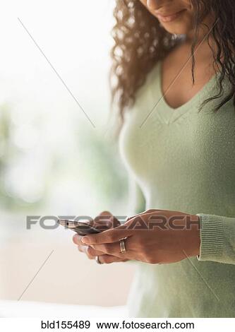 Stock Photo - Close up of mixed race woman using cell phone. Fotosearch