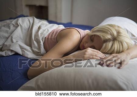 Stock Image - Close up of woman sleeping in bed. Fotosearch