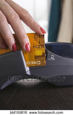 Close up of woman swiping credit card in credit card reader View Large Photo Image Stock Photograph - Close up of woman swiping credit card in credit card reader. Fotosearch