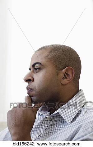 Stock Image - Close up profile of serious face of mixed race businessman. Fotosearch
