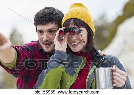 Stock Photo - Couple admiring view with binoculars. Fotosearch