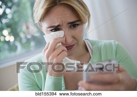 Picture - Crying Caucasian woman using cell phone. Fotosearch