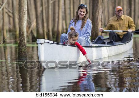 Picture - Family sitting together in canoe on river. Fotosearch