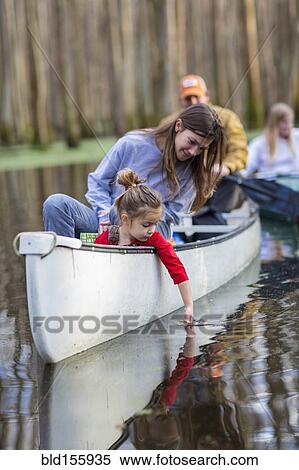 Family sitting together in canoe on river View Large Photo Image Stock Photography - Family sitting together in canoe on river. Fotosearch