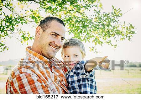 Stock Photo - Father and son pointing on farm. Fotosearch