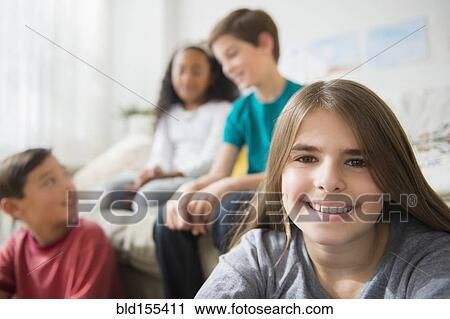 Girl smiling with friends in living room View Large Photo Image Stock Image - Girl smiling with friends in living room. Fotosearch