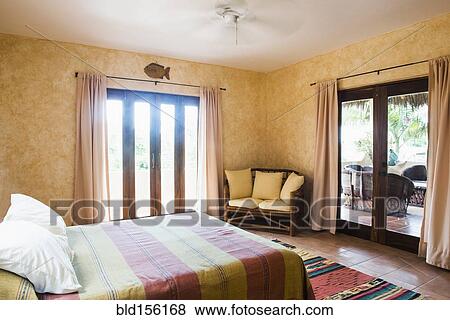 "Glass doors, bed and loveseat in bedroom" View Large Photo Image Stock Photo - "Glass doors, bed and loveseat in bedroom". Fotosearch