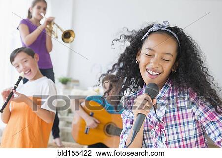 Stock Image - Happy children singing and playing music. Fotosearch