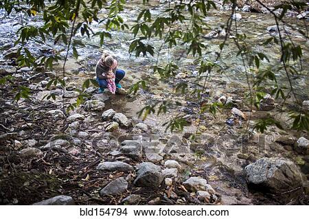 Picture - High angle view of Caucasian mother and baby at rocky river. Fotosearch
