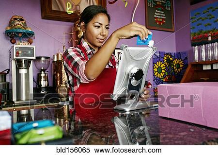Hispanic barista using digital tablet register in coffee shop View Large Photo Image Stock Photography - Hispanic barista using digital tablet register in coffee shop. Fotosearch