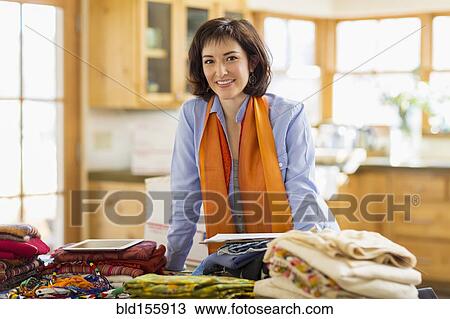 Hispanic business owner smiling in home office View Large Photo Image Stock Image - Hispanic business owner smiling in home office. Fotosearch