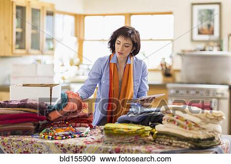 Hispanic business owner taking inventory with digital tablet in home office View Large Photo Image Stock Photo - Hispanic business owner taking inventory with digital tablet in home office. Fotosearch